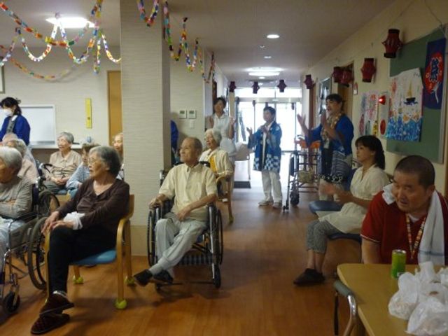 廊下での楽しい時 盆踊り 活気に満ちた廊下では、利用者様が集い様々な活動に興じています。ここでは日々の交流を通じて、心豊かな時間を過ごされている様子が伺えます。