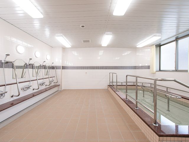 明るい浴室の一角 浴室 広々とした浴室には手すりが設置され、安全に配慮された環境です。清潔感があり、リラックスしてご利用いただける空間が整っています。