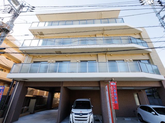 現代的な建物の外観 外観 清潔感ある新しい建物は、ご家族の訪問も快適な環境を提供しています。車も停めやすい広々とした前庭が印象的です。