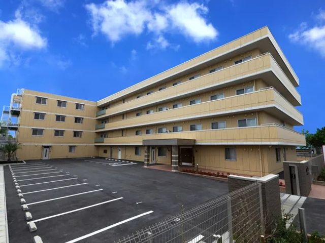 建物外観と駐車場の様子 外観   明るい色合いの建物と、広めの駐車スペースが見えます。就業時の出入りや来訪対応の動線をイメージしやすい外観です。