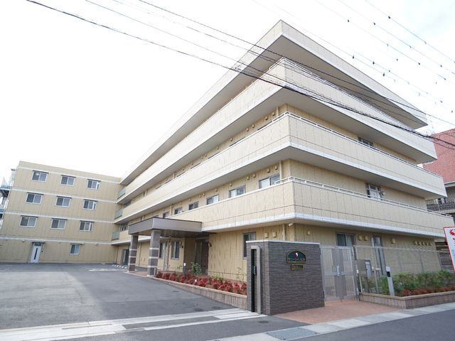 明るい外観の施設エントランス 外観 広々としたエントランスは、入居者の快適な日常生活を支える明るい第一歩です。清潔感溢れる設計で、働く環境としても理想的です。