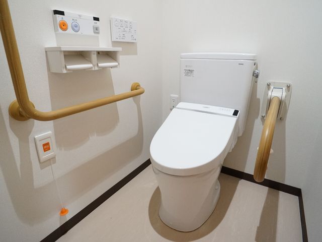 バリアフリートイレ設備 トイレ サポートを必要とされる方に配慮した設計の安全なトイレ空間です。手すりや緊急呼び出しボタンも完備しており、利便性を追求しています。