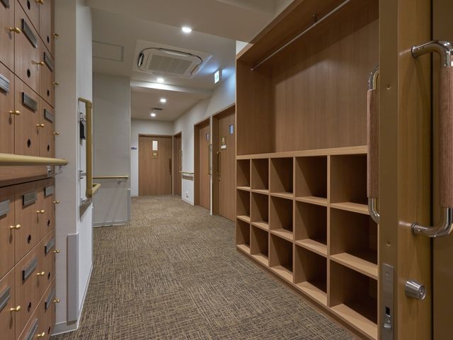 温かみのある廊下 廊下 温かみのある照明に包まれた廊下です。落ち着いた空間の中で安心して移動できます。