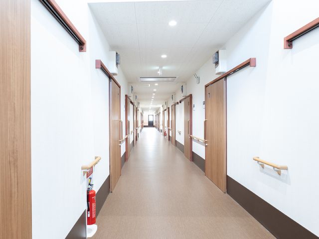 明るい広い廊下末尾 廊下 手すりが設置されたきれいで広々とした廊下です。安全かつ快適な移動をサポートします。