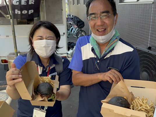 スタッフが食事を持つ外観  