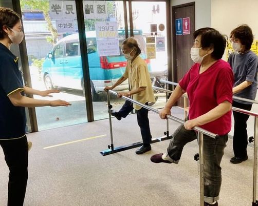 リハビリ訓練を行うスタッフと利用者