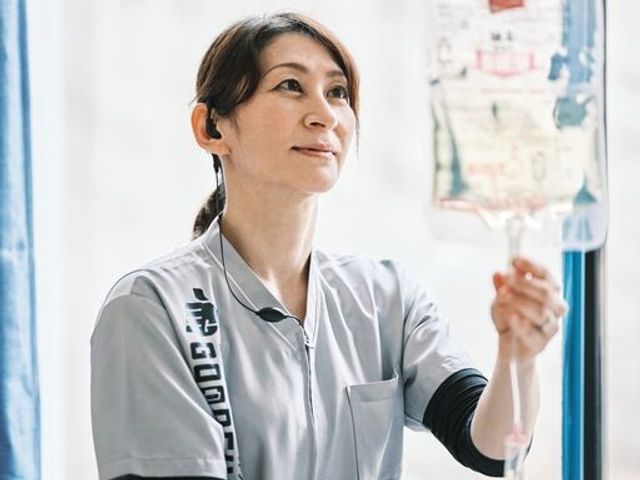 笑顔のスタッフと点滴 日常風景 優しい表情を浮かべるスタッフが、点滴の準備をしています。安心して勤務できる環境が整っています。