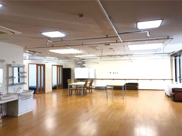 広い共有リビング リビング   木目の床が広がる明るい共有リビングです。テーブルや洗面台があり、ゆったり過ごせる空間です。
