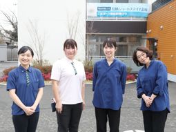 スタッフが笑顔で立つ外観