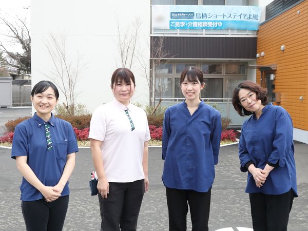 スタッフが笑顔で立つ外観