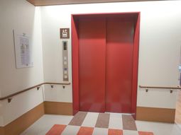 赤いエレベーターの前