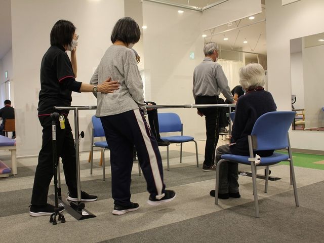 機能訓練を行う室内 機能訓練室 専門スタッフがサポートしながら、安全に機能訓練を行う場面です。利用者同士の交流も活発です。
