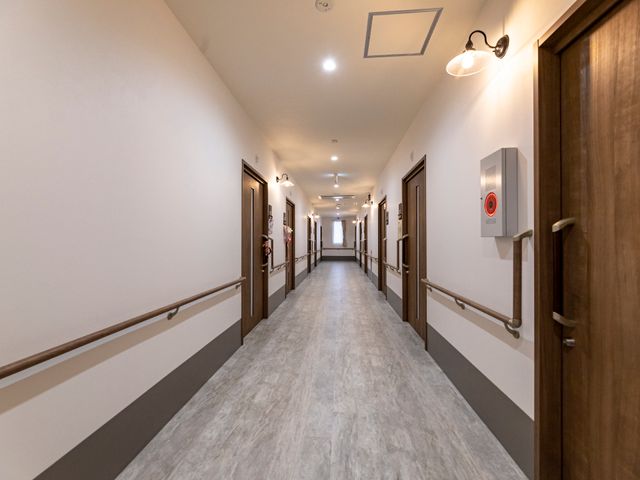 施設の明るい廊下 廊下 手すりが整った清潔感のある廊下です。通路の広さが快適な移動を支援します。