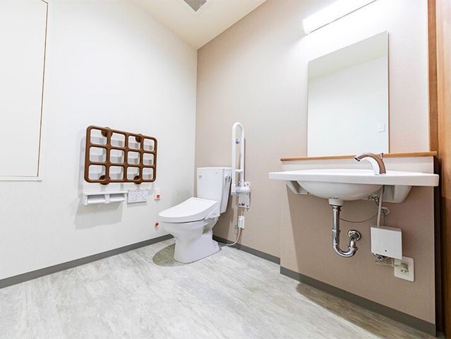 バリアフリートイレ トイレ 快適さと安全性を重視し、手すり付きの広々とした清潔なトイレです。利用者の自立支援に配慮した設計となっております。