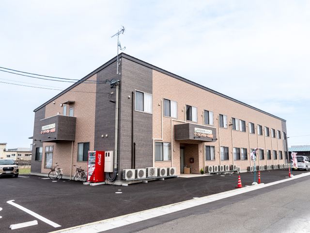 茶色の建物の外観 外観 広々とした駐車スペースを有する落ち着いた色調の建物です。周辺は開放的で、快適な職場環境が期待できそうです。
