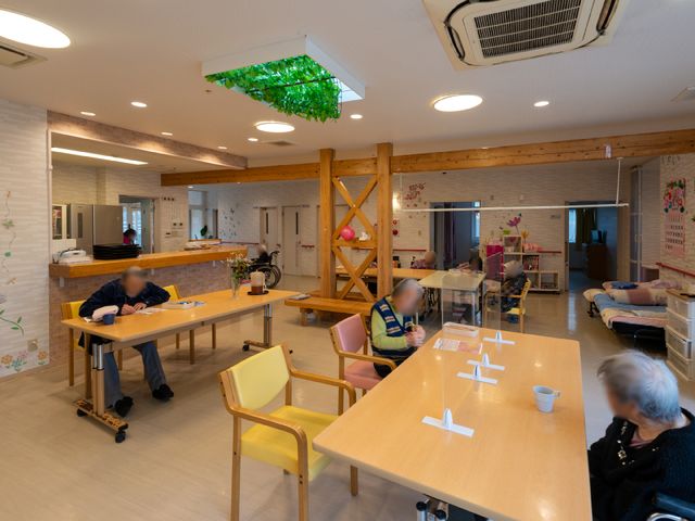 共有空間のリビング 共有スペース 木のぬくもりを感じる広々としたリビングで、居住者の方々がそれぞれの時間をゆったりと過ごされています。