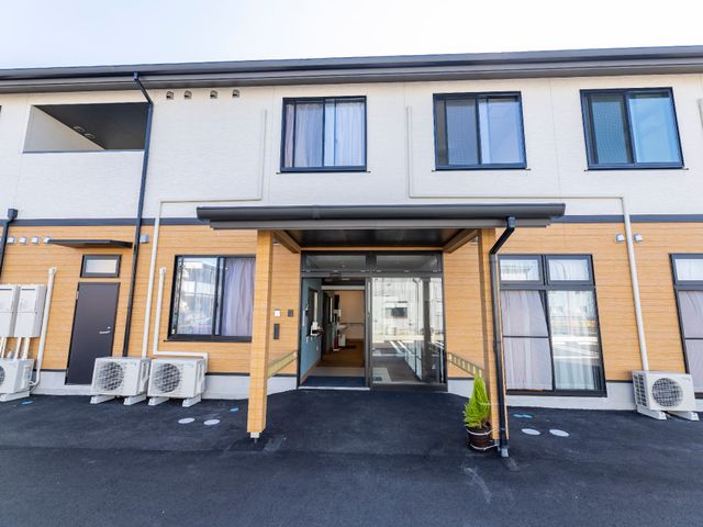 綺麗な建物のエントランス 外観 モダンな建築の門出を迎える場所。清潔感に溢れ、歓迎する雰囲気が漂います。