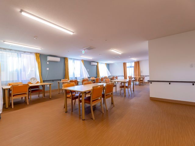 明るい食堂の様子 共有スペース 広々とした食堂は自然光が差し込み、快適な食事やコミュニケーションの場を提供しています。明るく開放感ある環境で、利用者様の食事の時間をサポートしています。