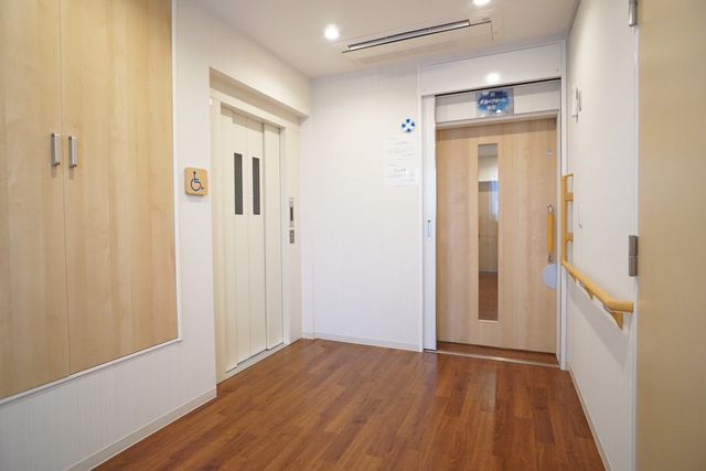 廊下とドアの明るい空間 内観 手すりが備えられた清潔感のある廊下が見受けられ、業務をするには環境が整っております。優しい雰囲気のドアが配され、訪れる方々を温かく迎えます。