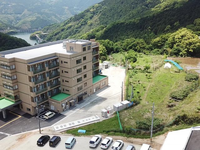 山間に立つ建物外観 外観 緑豊かな山間に位置する施設です。静かで落ち着いた環境での就業が可能です。