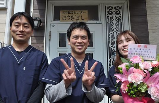 笑顔のスタッフが立つ玄関前