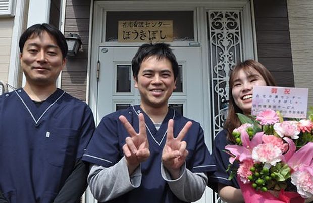 笑顔のスタッフが立つ玄関前