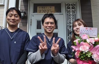 笑顔のスタッフが立つ玄関前