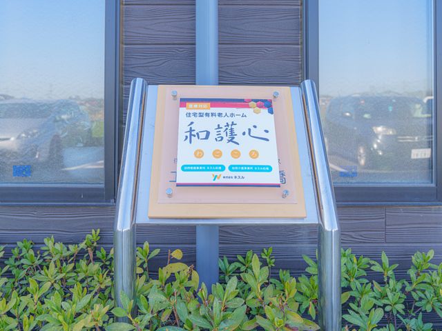 看板の前の緑 ロゴ 明るく分かりやすい表記の看板です。到着を一目で確認でき、安心感を与える設計となっています。