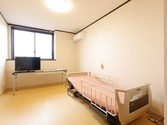 明るい居室のベッドとテレビ