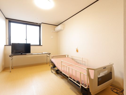 明るい居室のベッドとテレビ