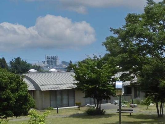 緑に囲まれた建物の外観  