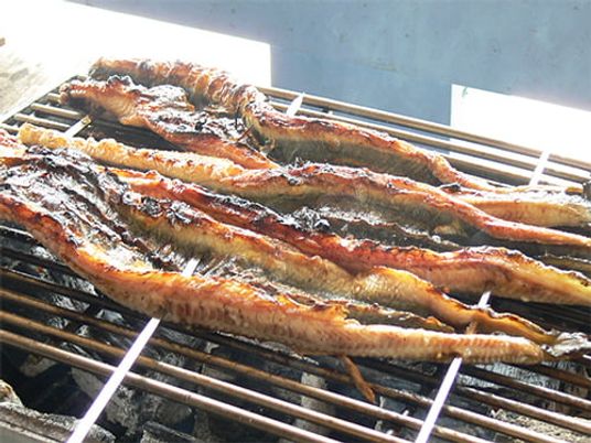 炭火で焼かれる魚料理