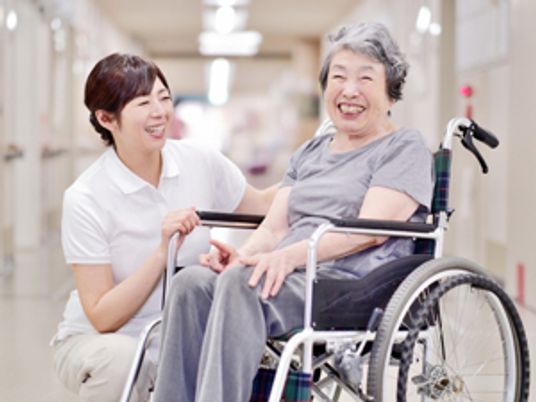 笑顔の女性と利用者廊下