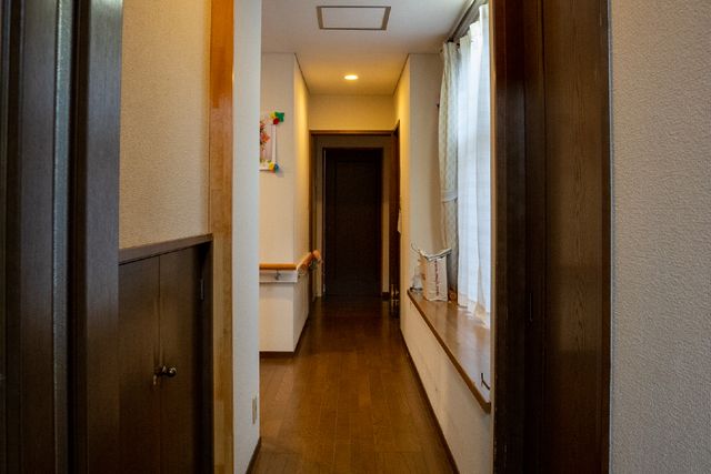 廊下の落ち着いた雰囲気 廊下 手すりが設置された落ち着いた色調の廊下です。清潔感があり、静かな環境での勤務をご希望の方に適しています。