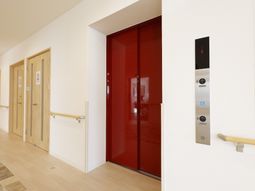赤い扉とエレベーターの廊下