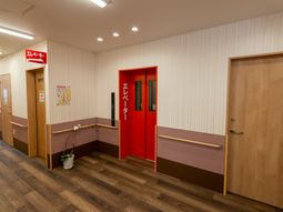 明るい廊下と赤いエレベーター