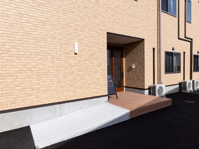 明るい建物のエントランス 玄関 招待感のあるエントランスは、来訪者を温かく迎えます。ここから新しい職場生活が始まります。