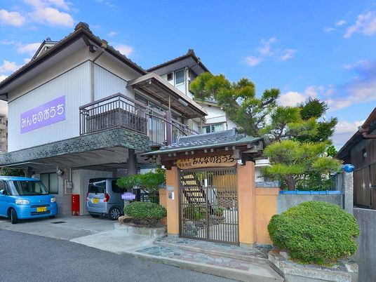 白と紫の立て看板が目立つ外観