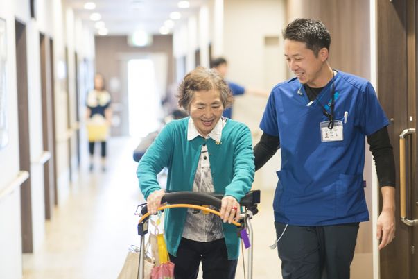 笑顔で歩行訓練を支援する廊下