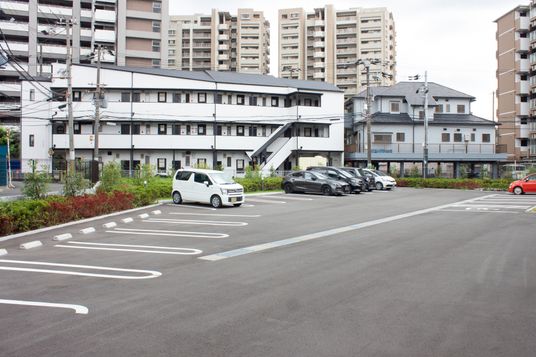 白日の駐車場と施設外観