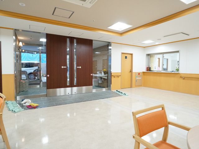 明るいエントランスの様子 玄関 広々としたエントランスは、明るく暖かい雰囲気が迎えてくれます。訪問者や職員にも安心感を与える空間です。