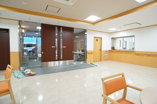 明るいエントランスの様子 玄関 広々としたエントランスは、明るく暖かい雰囲気が迎えてくれます。訪問者や職員にも安心感を与える空間です。