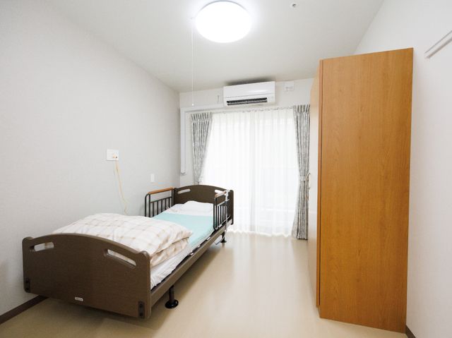 清潔な個室の居室 居室 明るい窓辺、清潔で落ち着いた雰囲気の居室です。入居者のプライバシーと快適さを大切に設計されています。