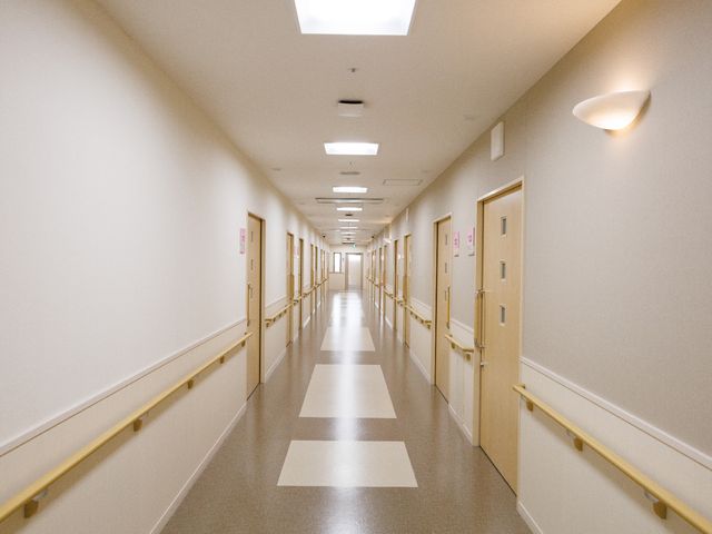 明るい照明の廊下 廊下 清潔感のある広々とした廊下は、移動がしやすく機能的な設計です。手すりが付いており、安心して歩行できる環境が整っています。