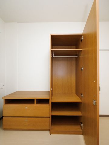 開いた木製クローゼット 居室 シンプルで使い勝手の良い木製クローゼットが整っており、快適な居住空間をご提供します。