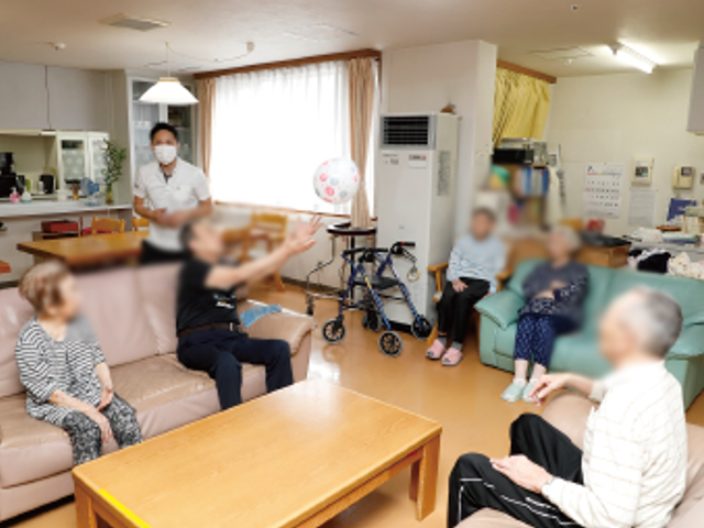リビングの様子 リビング 自然光が差し込む明るいリビングで、利用者がリラックスして過ごしています。空間は広く、居心地の良さを感じられます。