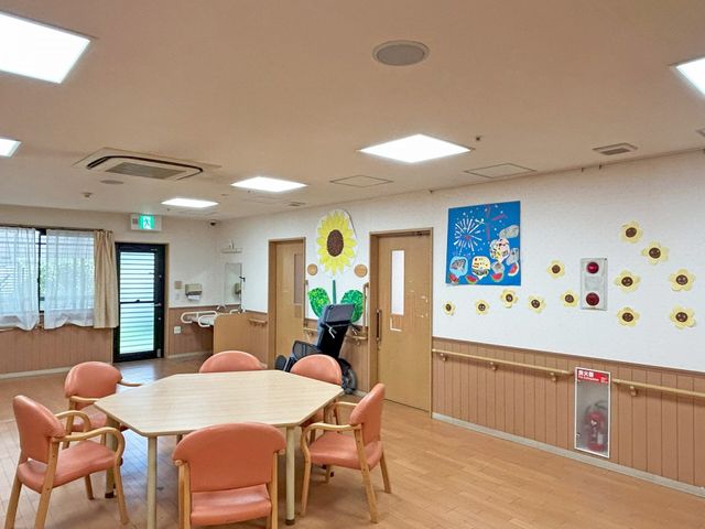 明るいテーブルのある部屋 ダイニングルーム 広々とした明るい部屋で、木製のテーブルと椅子が配置されています。壁の装飾が楽しい雰囲気を作っています。