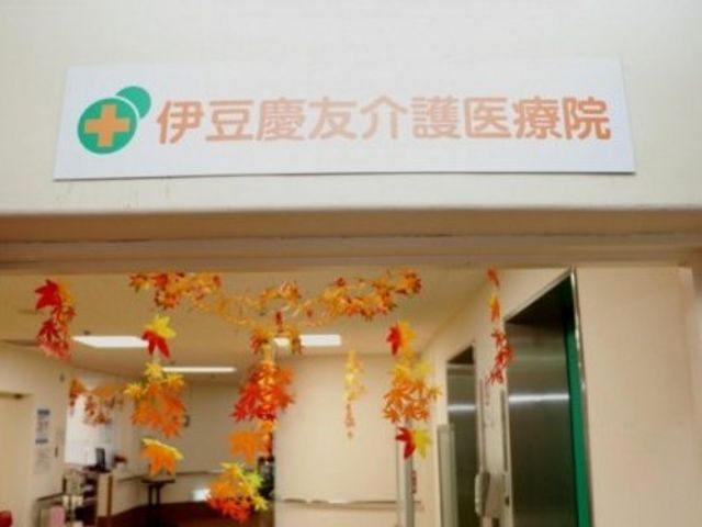伊豆慶友介護医療院の入口 エントランス   看板が掲げられた入口です。紅葉の飾りが下がり、明るい雰囲気で迎えてくれます。