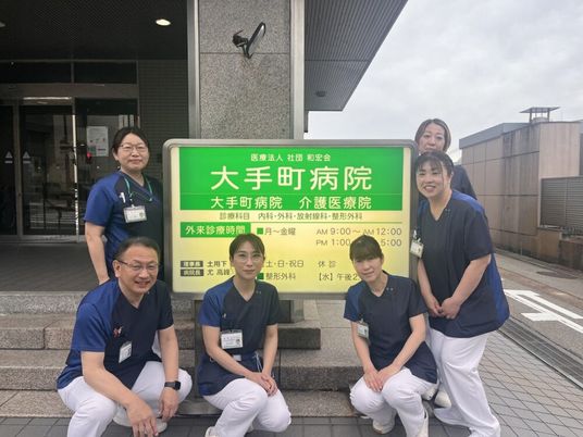 病院前の看板と職員  