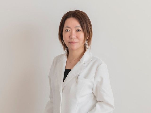白衣の女性スタッフ スタッフイメージ   白衣を着た女性スタッフが、やわらかな表情で正面を向いています。就業時の雰囲気をイメージしやすい一枚です。